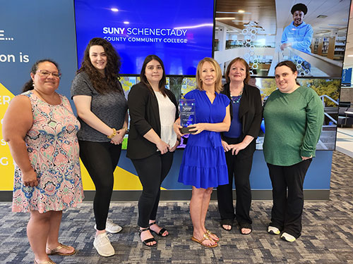 Members of the Academic Advising team in 2023 holding their Holistic Advising Award from the Advising Success Network (ASN).