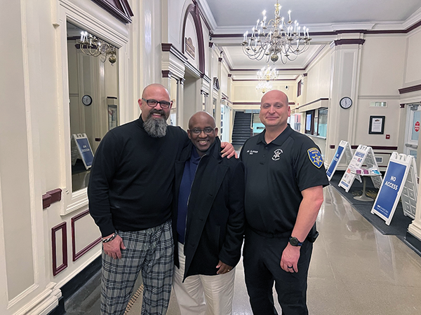 Eric Fluty, Dr. Steady Moono, and Joe Glasser standing in Elston Hall.