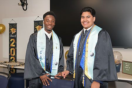 Two Early College High School graduates wearing their gowns at Commencement in 2025.
