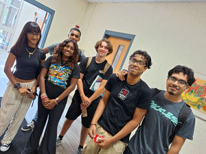 Group of students standing together, looking happy.