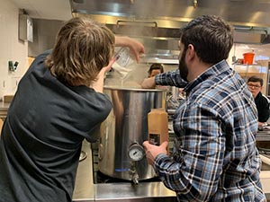 Students working in the culinary lab, brewing beer.