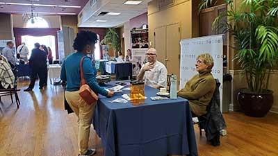 Student speaking to employers at a table at a career fair.