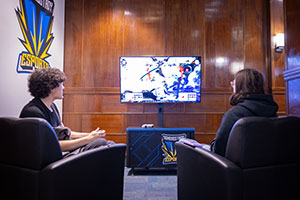 Students in lounge chairs in the eSports Arena's casual gaming area.