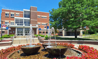 The Quad at SUNY Schenectady in the summer, flower blooming around the fountain.