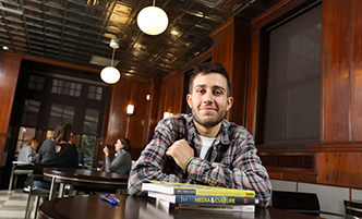 Student sitting in the cafe with communications textbooks. 