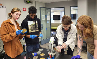 Student looking into a test tube in the Biotechnology lab. 