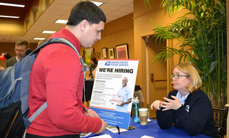 Student speaking with a recruiter at an employment fair.