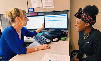 Academic Advising staff member working in front of a computer with a student. 