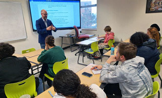Faculty member in front of a classroom full of students. 