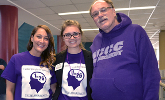 Director of Disability Services standing with two students in epilepsy awareness tee shirts.