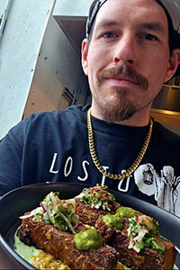 Close up of Chef Stephen Barrett holding a plate of artfully plated food.