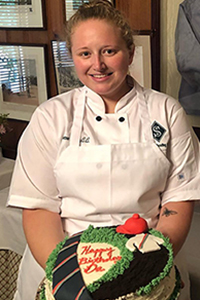 Vanessa Traver holding a decorated cake.