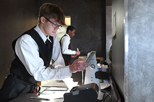 Students working on a POS system in the management area of Casola Dining Room.