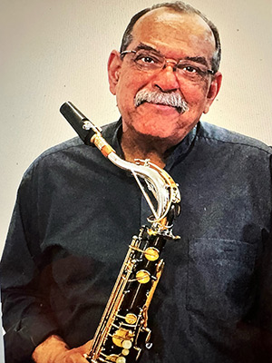 Ernie Watts holding his saxophone.