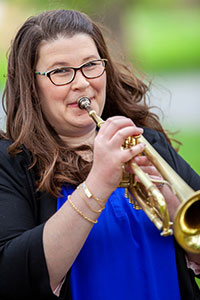 Dr. Allyson Keyser playing a trumpet.