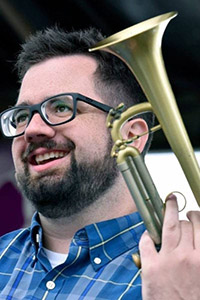 Headshot of Dylan Canterbury holding a trumpet.