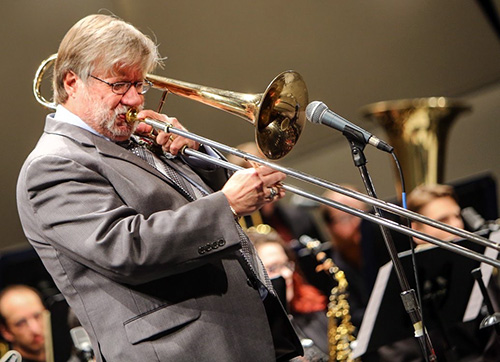 Bill Meckley playing his trombone on stage with the Empire Jazz Orchestra.