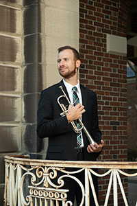 Headshot of John Fatuzzo holding a trumpet.