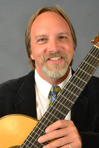 Headshot of Sten Isachsen holding a guitar