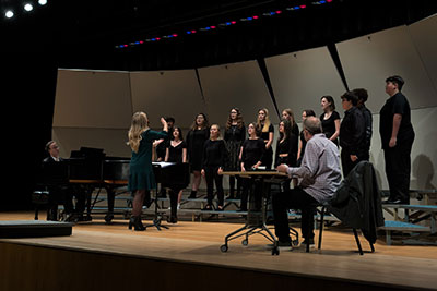 Choral workshop instructor working with students on stage in 2023. 