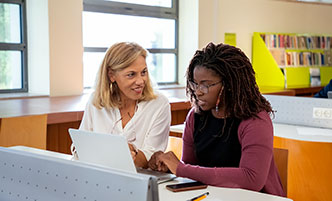 Two women working together in a library.