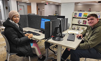 Two students working on computers in the Learning Commons.