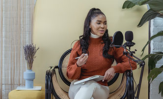 Woman in a home setting, recording a podcast.