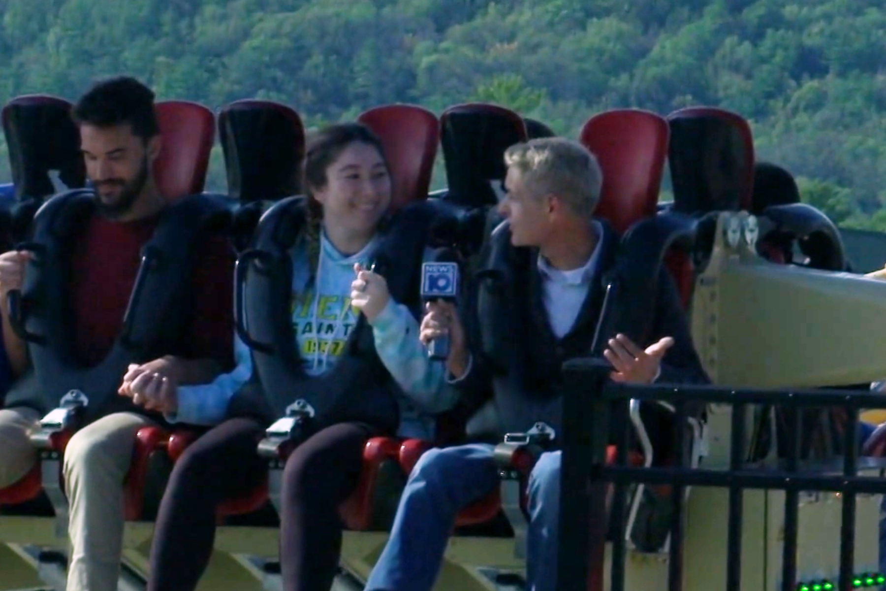 James De La Fuente holding NEWS10 microphone, riding rollercoaster, conducting interview at Altamon Fair