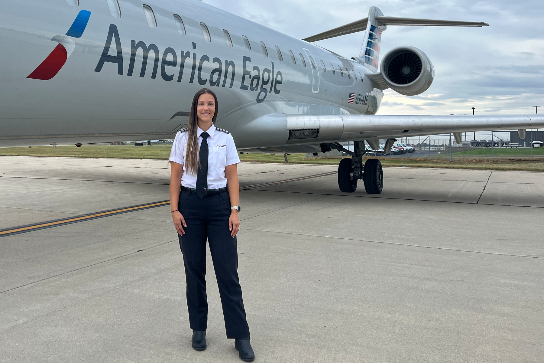 Pilot Lisa Deemer stands on the tarmack in front of a CRJ 900 she flies for PSA Airlines.
