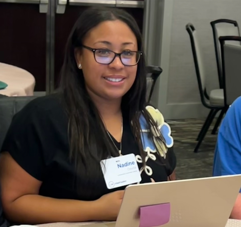 Nadine Davila sitting at table with laptop in front of her