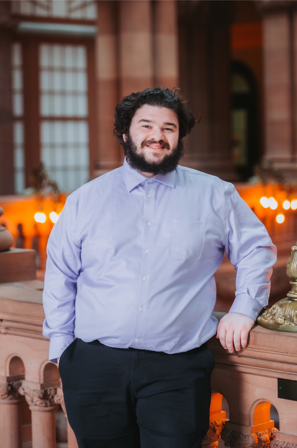 Nate Friedman, smiling, standing up in New York State Senate office